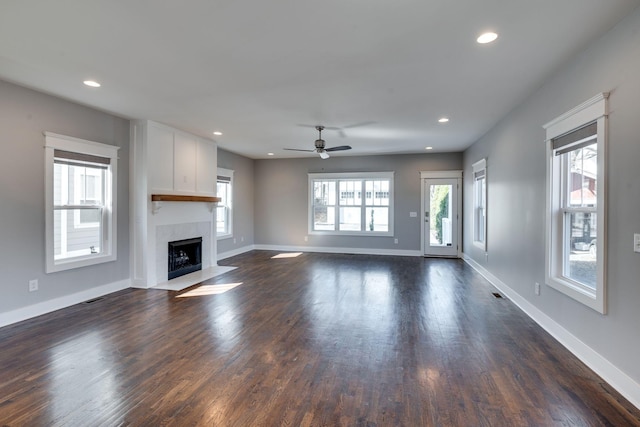 unfurnished living room with a premium fireplace, baseboards, dark wood-type flooring, and recessed lighting