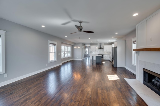 unfurnished living room featuring a fireplace, a ceiling fan, dark wood-style flooring, and recessed lighting