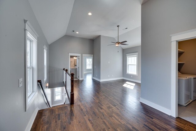 unfurnished living room with lofted ceiling, ceiling fan, baseboards, independent washer and dryer, and dark wood finished floors