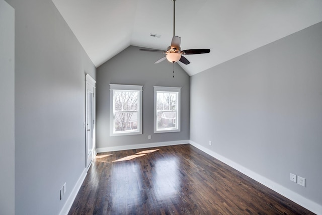 unfurnished room with lofted ceiling, visible vents, dark wood finished floors, and baseboards