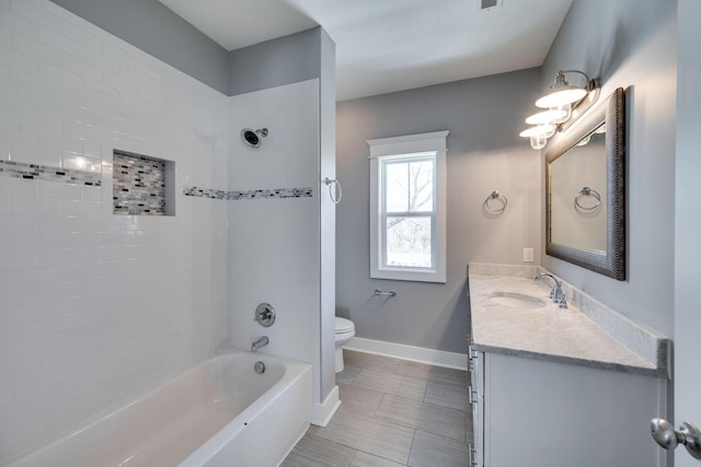 bathroom with visible vents, baseboards, toilet, vanity, and shower / bathing tub combination