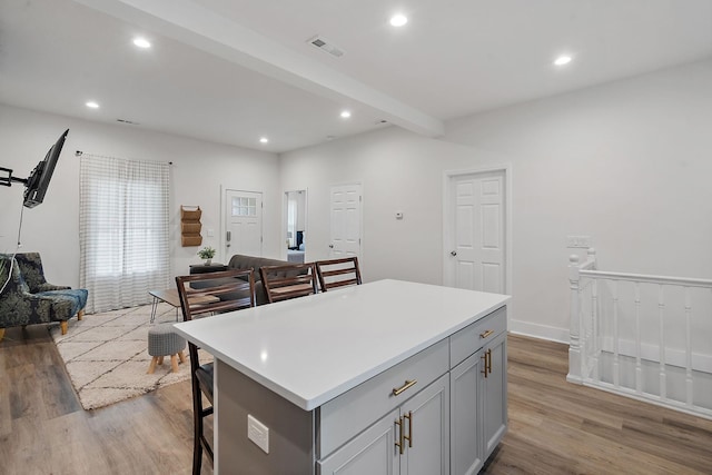 kitchen with open floor plan, wood finished floors, visible vents, and gray cabinetry