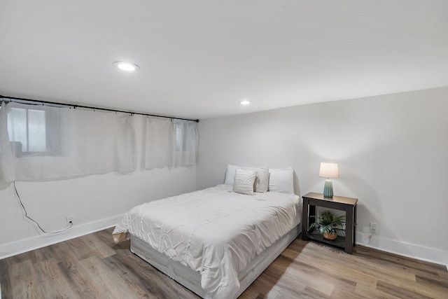 bedroom with recessed lighting, baseboards, and wood finished floors