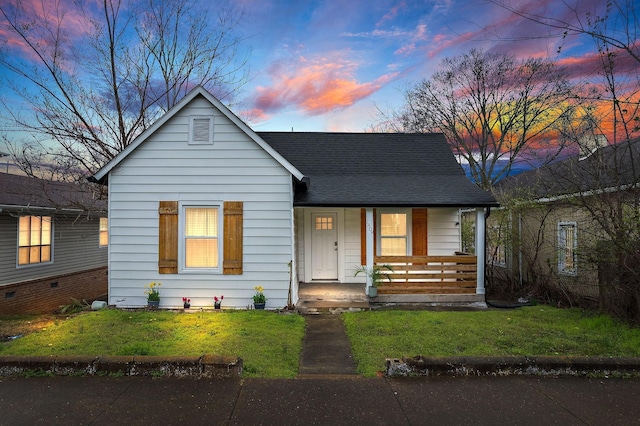 bungalow-style house with a porch, a front yard, and a shingled roof