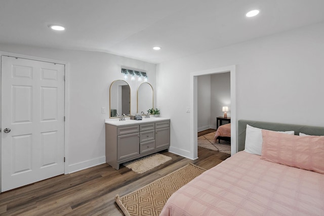 bedroom with recessed lighting, a sink, dark wood finished floors, and baseboards