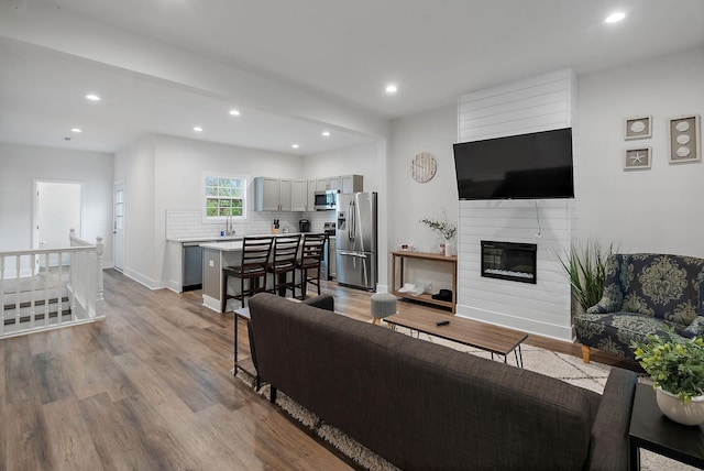 living area featuring a fireplace, wood finished floors, and recessed lighting