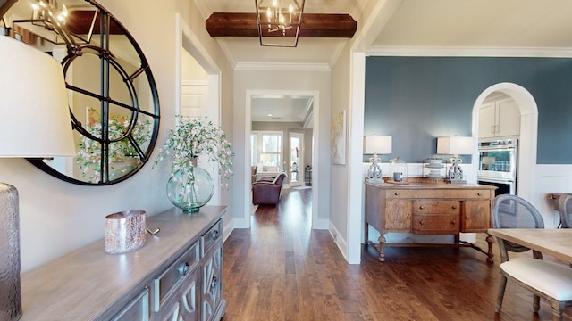 interior space with dark wood-style floors, arched walkways, beam ceiling, crown molding, and baseboards