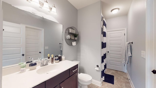 bathroom with toilet, baseboards, and vanity