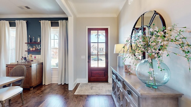 foyer entrance with dark wood-style floors, baseboards, visible vents, and crown molding