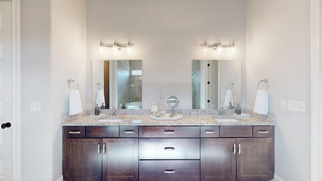 bathroom featuring double vanity, a sink, and baseboards