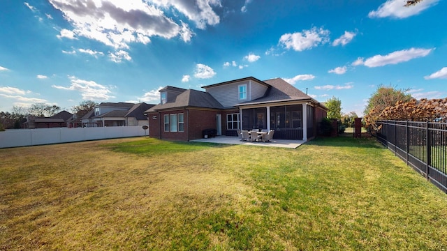 rear view of property featuring brick siding, a yard, a sunroom, a patio area, and a fenced backyard