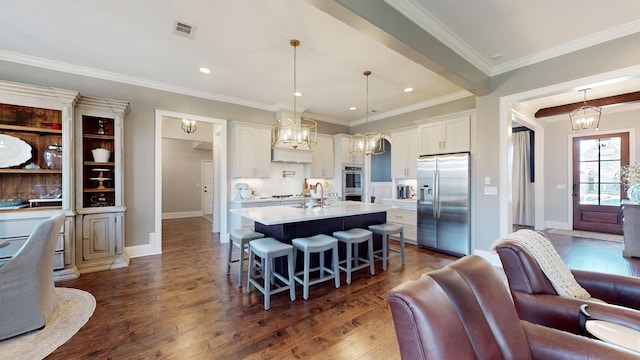 kitchen with an inviting chandelier, stainless steel appliances, dark wood-style flooring, and light countertops