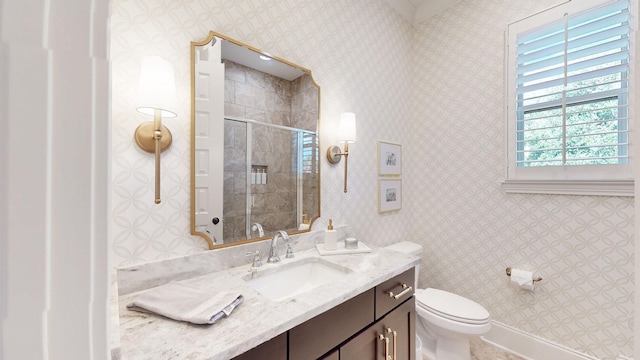 full bath featuring toilet, wallpapered walls, vanity, and a stall shower