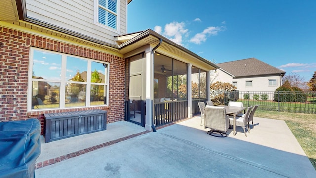 view of patio featuring outdoor dining area, fence, and a sunroom