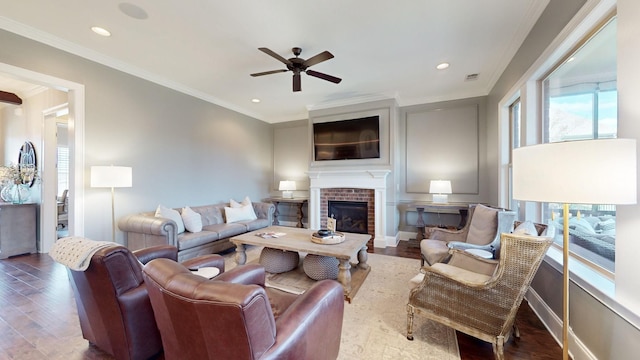 living room with recessed lighting, a brick fireplace, wood finished floors, and crown molding