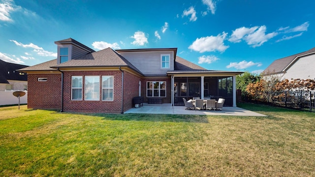 back of property featuring brick siding, a yard, a patio, a sunroom, and fence