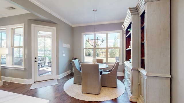 dining space with dark wood-style flooring, a notable chandelier, crown molding, and baseboards