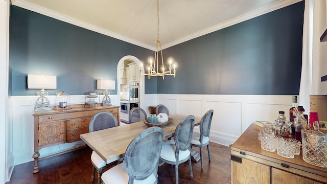 dining space with a chandelier, dark wood-style flooring, wainscoting, and ornamental molding