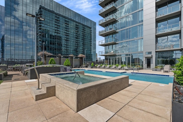 pool featuring a patio and a hot tub