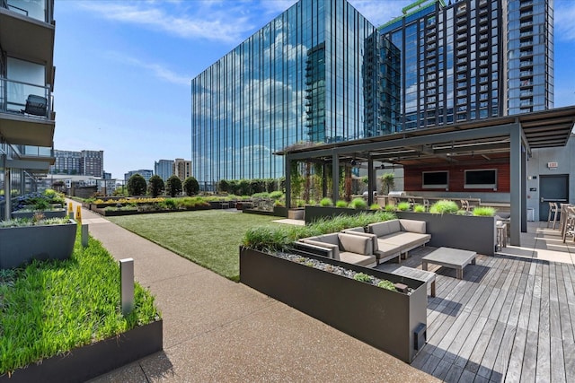 view of property's community with a lawn, outdoor lounge area, and a city view