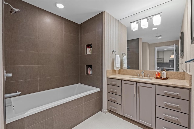 bathroom featuring tiled shower / bath, visible vents, vanity, and tile patterned floors