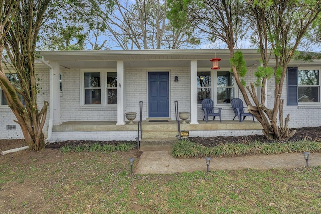 view of front of house with a porch and brick siding