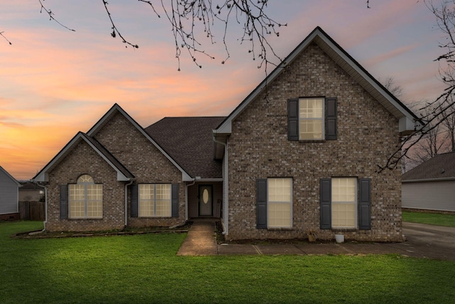 traditional home with brick siding and a lawn