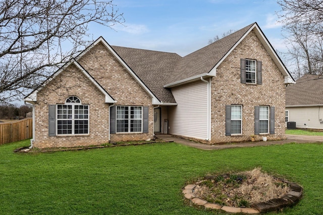 traditional-style home featuring brick siding, fence, and a front yard