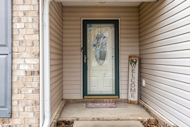 entrance to property featuring brick siding