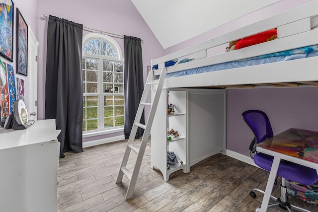 bedroom with baseboards, vaulted ceiling, and wood finished floors