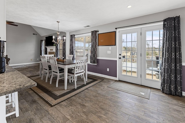 dining area with baseboards, vaulted ceiling, and dark wood finished floors