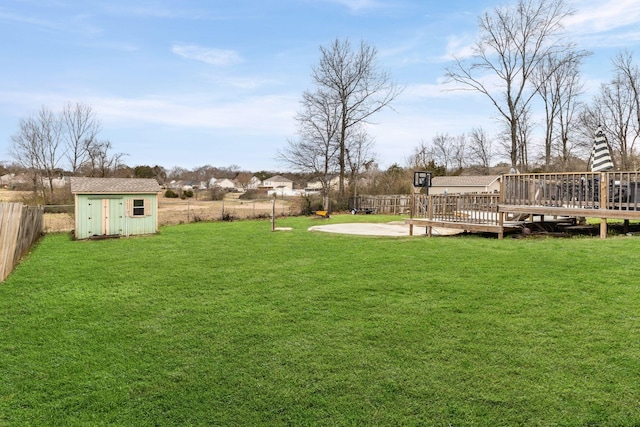 view of yard featuring a fenced backyard, an outdoor structure, a deck, and a storage shed