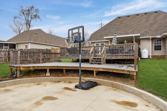 exterior space with roof with shingles, fence, a deck, a yard, and a patio area