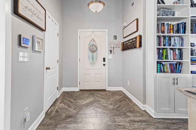 foyer featuring parquet flooring, baseboards, and visible vents