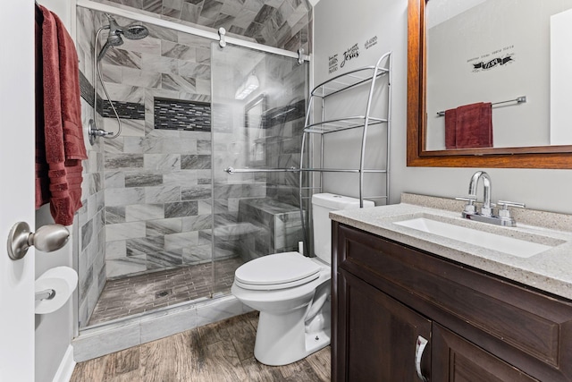 full bath featuring toilet, a shower stall, wood finished floors, and vanity