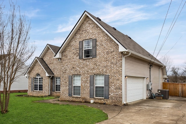 view of front facade with cooling unit, concrete driveway, brick siding, and a front yard