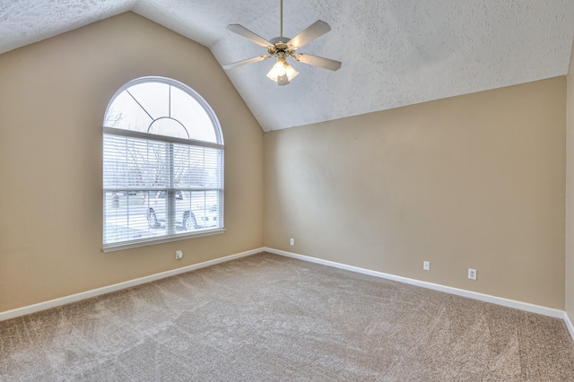 unfurnished room featuring carpet, ceiling fan, lofted ceiling, and a textured ceiling