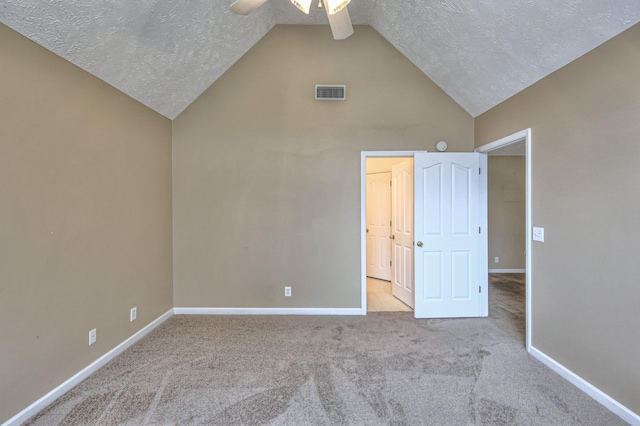 unfurnished bedroom with lofted ceiling, a textured ceiling, carpet floors, visible vents, and baseboards