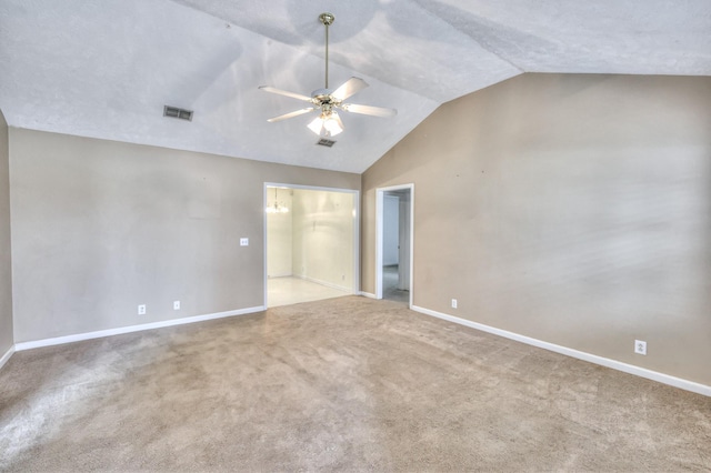 unfurnished room with carpet floors, visible vents, baseboards, vaulted ceiling, and a ceiling fan