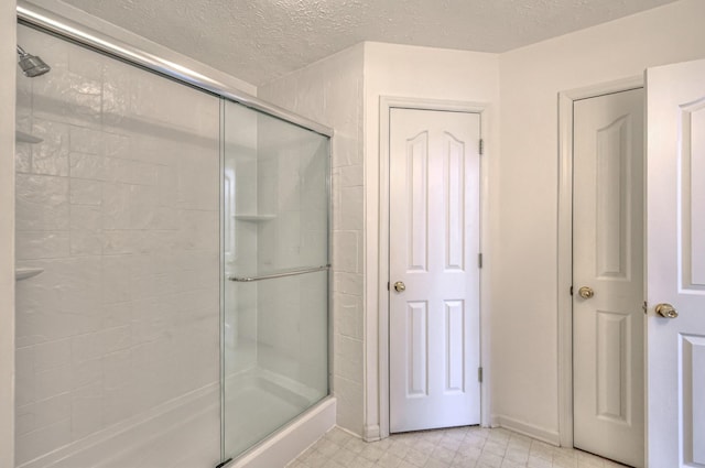 bathroom featuring a shower stall and a textured ceiling