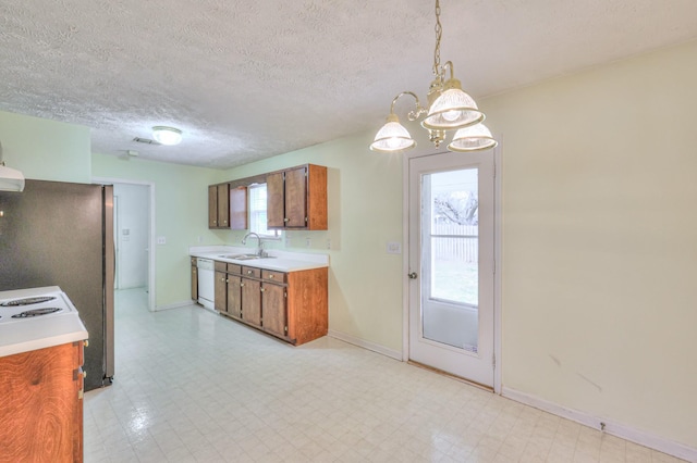 kitchen featuring brown cabinetry, white dishwasher, light countertops, light floors, and a sink