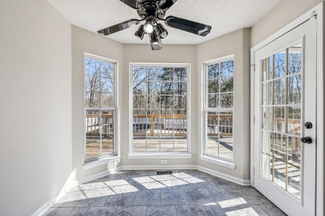 unfurnished sunroom with ceiling fan, plenty of natural light, and visible vents