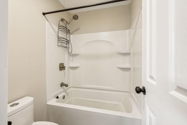 bathroom featuring tub / shower combination and toilet