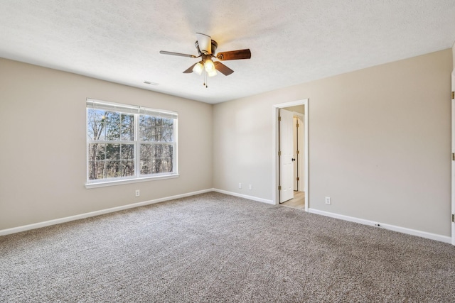 empty room with visible vents, a ceiling fan, light carpet, a textured ceiling, and baseboards