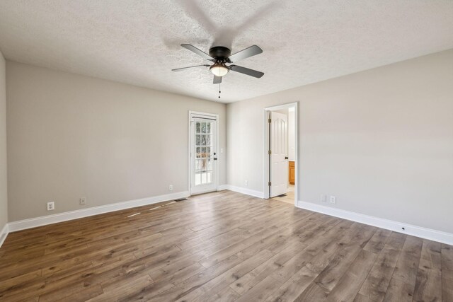 spare room with baseboards, a textured ceiling, a ceiling fan, and wood finished floors