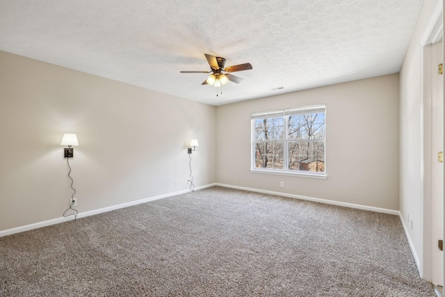 spare room featuring a textured ceiling, carpet flooring, a ceiling fan, and baseboards