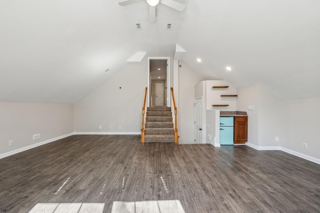 unfurnished living room with dark wood-style floors, lofted ceiling, a ceiling fan, baseboards, and stairs