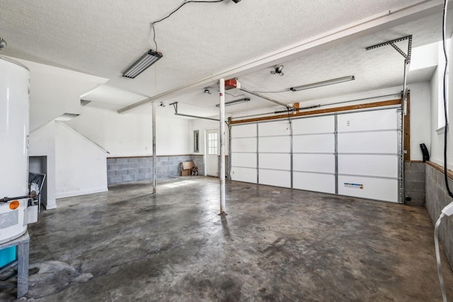 garage featuring concrete block wall and a garage door opener