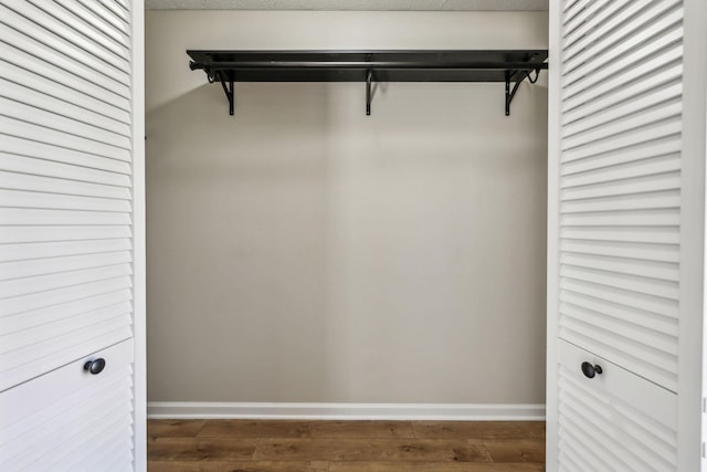 walk in closet with wood finished floors