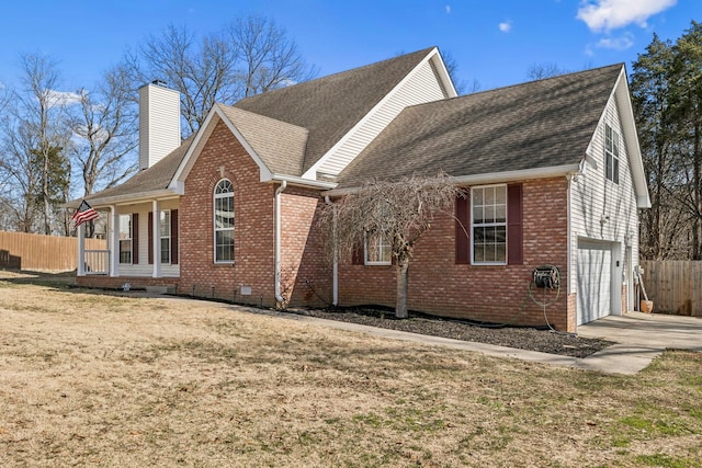 view of side of home with crawl space, brick siding, a chimney, and driveway